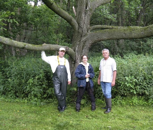 Photo de Caroline Tanguay et d'intervenants, devant un tronc de noyer cendré