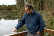 Photo de Claude Roy, animateur à la Maison de l'arbre, devant un étang