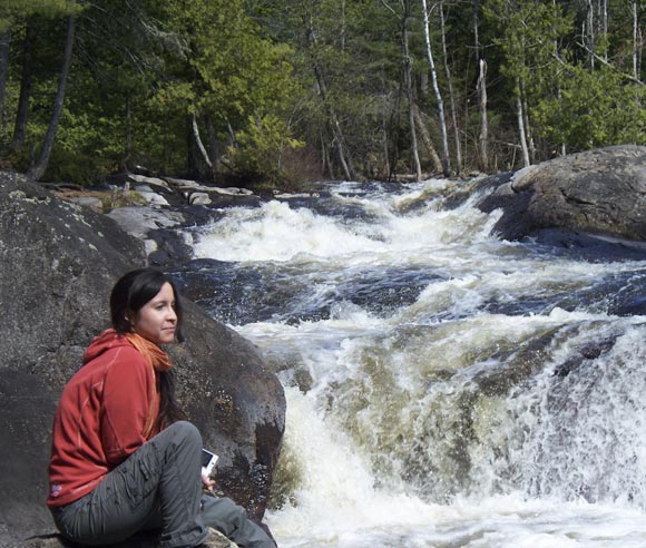 Photo d'Édith Bégin, en forêt, devant une cascade d'eau